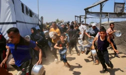 Des Gazaouis se ruent sur une distribution d'aide alimentaire à Khan Younès, dans le sud de la bande de Gaza, le 22 juillet 2025