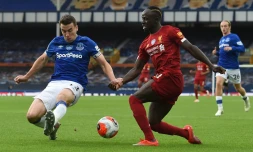 Le défenseur d'Everton Seamus Coleman (g) à la lutte avec l'attaquant de Liverpool Sadio Mané, le 21 juin 2020 à Liverpool  