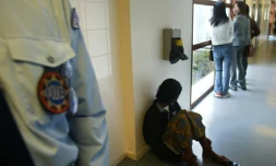 Des personnes sous la surveillance d'un policier, le 27 octobre 2003 dans le centre de rétention de la zone d'attente de l'aéroport de Roissy-Charles de Gaulle