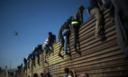Des migrants centraméricains grimpent sur la barriÚre métallique marquant la frontiÚre entre le Mexique et les Etats-Unis à Tijuana, le 25 novembre 2018
