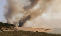 De la fumée s'élève de l'incendie qui ravage la forêt de pins en contrebas de la dune du Pyla, en Gironde, le 18 juillet 2022
