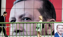 Des personnes marchent devant une affiche du président Recet Tayyip Erdogan le 6 avril 2017 à Istanbul