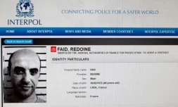 Une reproduction du site d'Interpol montrant la fiche de recherche du braqueur français Redoine Faïd, échappé de sa prison de Réau (Seine-et-Marne) le 1er juillet 2018