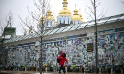 Une personne passe devant le Mur du Souvenir des Morts pour l'Ukraine à Kiev, le 25 février 2026