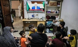 Une famille palestinienne assiste au discours du président de l'Autorité palestinienne Mahmoud Abbas à la télévision, à Rafah (Territoires palestiniens), le 29 avril 2021