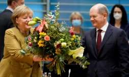 La chancelière allemande Angela Merkel reçoit un bouquet de fleurs d'Olaf Scholz (d), candidat du parti social-démocrate à la chancellerie, le 24 novembre 2021 à Berlin