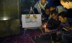 Des journalistes se recueillent mercredi 3 mai devant une photo de Shah Marai et de Sardar Ahmad, deux reporters de l'AFP tués en Afghanistan.