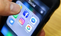 Un homme tient un smartphone sur lequel on voit des icones dont celui de l'application Facebook, à Moscou le 23 mars 2018