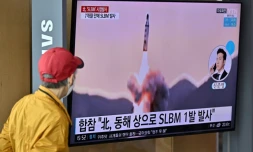 Passant regardant un tir de missile nord-coréen sur un écran de la gare de Séoul, le 7 mai 2022