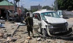 Un soldat près d'une voiture endommagée dans un attentat à la bombe, le 2 janvier 2017 à Mogadiscio, en Somalie