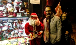 Un Iranien pose à côté d'un petit père Noël à Téhéran, le 24 décembre 2016