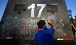 Un manifestant écrit "Assassins" sur un véhicule de la police lors d'une manifestation à Santiago du Chili le 3 novembre 2019
