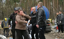 Une femme s'effondre aprÚs la découverte du corps de son fils dans une fosse prÚs de Bouzova, le 10 avril 2022 à l'ouest de Kiev, en Ukraine