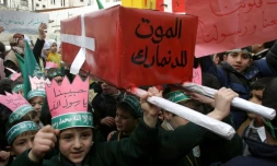 De jeunes Palestiniens défilent à Hébron, en Cisjordanie, le 13 février 2006 avec un faux cercueil ceint d'un drapeau danois sur lequel est inscrit "Mort au Danemark", en réaction à la parution en 2005 de caricatures de Mahomet dans un journal danois