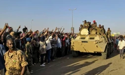 Des manifestants soudanais font le signe de la victoire en direction de militaires de l'armée à Khartoum, le 7 avril 2019