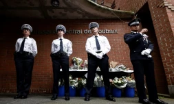 Des policiers se tiennent près d'un mémorial improvisé en hommage aux trois policiers tués le 21 mai devant un commissariat de Roubaix, dans le nord de la France, le 23 mai 2023