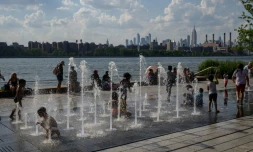 Des enfants se rafraîchissent dans une fontaine, le 30 juin 2021 à New York