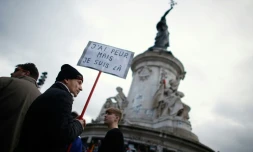 Un homme porte une pancarte à l'occasion du rassemblement en hommage aux victimes des attentats, le 10 janvier 2016 à Paris