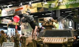 Un visiteur fait le poirier sur un véhicule de l'armée allemande, sur le stand de la Bundeswehr, au plus grand salon mondial du fitness, la Fibo, à Cologne (ouest de l'Allemagne), le 16 avril 