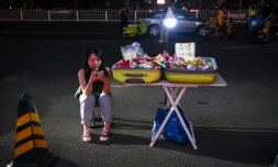 Une vendeuse de rue au bord de la route devant un centre commercial à Pékin, le 10 juin 2020