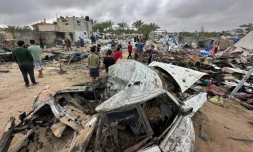 Des Palestiniens au milieu des dégâts dans le camp de déplacés à Al-Mawassi visé par des frappes israéliennes, dans le sud de la bande de Gaza, le 18 mai 2025
