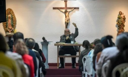 Rafael Arango, président de la Corporation Bethléem Maison Fraternelle, délivre son message assis dos au crucifix face à des dizaines de croyants de tous âges, le 2 septembre 2017 dans le nord-ouest de Bogota