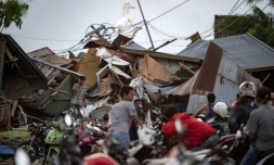 Des indonésiens récupèrent des affaires dans les décombres de leurs maisons après un séisme et un tsunami à Palu, dans l'île des Célèbes, le 29 septembre 2018