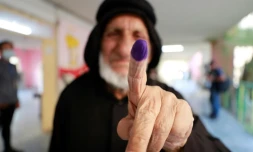 Une Irakienne montre son index teinté d'encre après avoir voté aux législatives à Bagdad, le 10 octobre 2021
