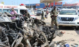 Un soldat se tient près de la carcasse d'une voiture détruite par un attentat qu a fait au moins 76 morts le 28 décembre 2019 à Mogadiscio.