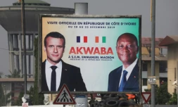 Une affiche montrant Emmanuel Macron (g) et son homologue ivoirien Alassane Ouattara à Abidjan le 19 décembre 2019