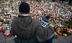 Des personnes se recueillent devant un mémorial de fleurs et de bougies en gommage aux victimes de l'attaque de Magdebourg, le 23 décembre 2024 à Magdebourg en Allemagne
