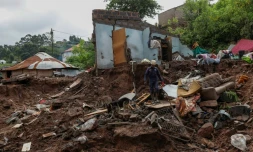 Un secouriste sud-africain explore les décombres avec un chien le 15 avril 2022 prÚs de Durban en Afrique du Sud, aprÚs les inondations et glissements de terrain provoqués par de fortes pluies dans l'est de l'Afrique du Sud