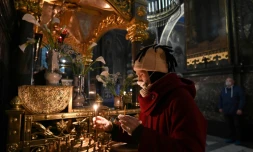 Une fidÚle allume un cierge dans la cathédrale orthodoxe Saint Volodymyr presque déserte à Kiev le 18 avril 2020