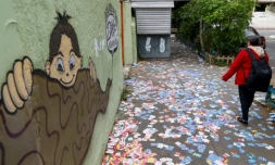 Une femme marche parmi les tracts de candidats aux municipales brésiliennes, le 6 octobre 2024, à Sao Paulo