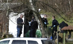 Des gendarmes et des experts en médecine légale fouillent une cabane de jardin le long d'une route près de Domessin dans l'est de la Savoie le 14 février 2018