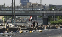 Un drapeau irakien est brandi lors d'une manifestation contre le pouvoir à Bagdad, le 4 octobre 2019