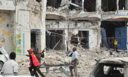 Des habitants transportent un blessé après une double explosion près d'un hôtel de Mogadiscio, le 25 janvier 2017 en Somalie