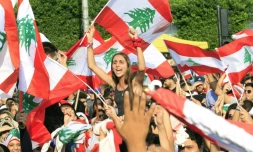 Des manifestants brandissent des drapeaux libanais lors d'un rassemblement contre le pouvoir, Ă SaĂŻda, dans le sud du Liban, le 19 octobre 2019