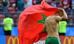 Le milieu de terrain Fayçal Fajr quitte la pelouse avec le drapeau marocain sur le dos, après l'élimination de son équipe du Mondial, battue par le Portugal le 20 juin 2018 à Moscou