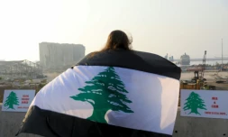 Une femme enveloppée dans un drapeau libanais bordé de noir manifeste à Beyrouth, le 6 septembre 2020 un mois après l'explosion meurtrière