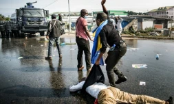Un partisan de l'opposant gabonais Jean Ping évacue un blessé lors d'une manifestation dénonçant la réélection d'Ali Bongo, le 31 août 2016 à Libreville