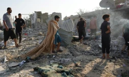 Des Palestiniens inspectent les décombres d'un bâtiment après un bombardement israélien à Khan Younès, dans le sud de la bande de Gaza, le 27 août 2024