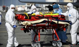 Le personnel médical transporte un patient infecté par le Covid-19 qui a été transféré de Nice, où les unités de soins intensifs sont surchargées, le 16 mars 2021 à Toulouse-Blagnac