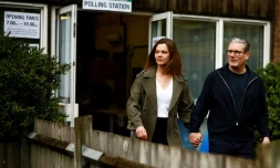 Keir Starmer, le principal chef du parti travailliste d'opposition britannique, et son épouse Victoria Starmer quittent un bureau de vote à Londres, aprÚs avoir voté pour les élections locales, le 2 mai 2024