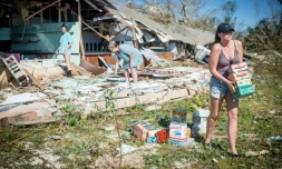 Une famille récupère des marchandises dans une boutique détruite leur appartenant, à Panama City le 11 octobre 2018.