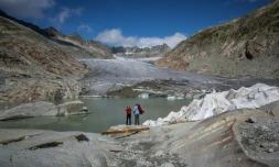 Des touristes devant le glacier du Rhône près de Gletsch, dans les Alpes suisses, le 12 septembre 2025