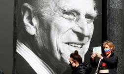 Deux passantes devant le portrait de feu le prince Philip, Ă Windsor (Royaume-Uni), le 16 avril 2021