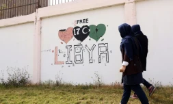 Des étudiants passent à côté d'un graffiti "Libye libre", à Tripoli, le 31 mars 2016