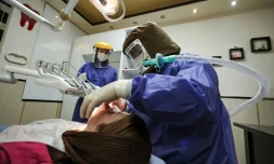 Des stomatologues iraniens portents des costmes de protection contre le Covid-19 dans leur cabinet à Téhéran, le 26 avril 2021.