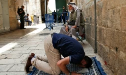 Un palestinien prie à l'extérieur de l'esplanade des Mosquées, le 26 juillet 2017 à Jérusalem